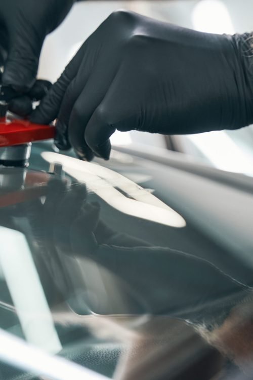 Car service specialist check crack on front window closeup. Car windshield repair with special tool